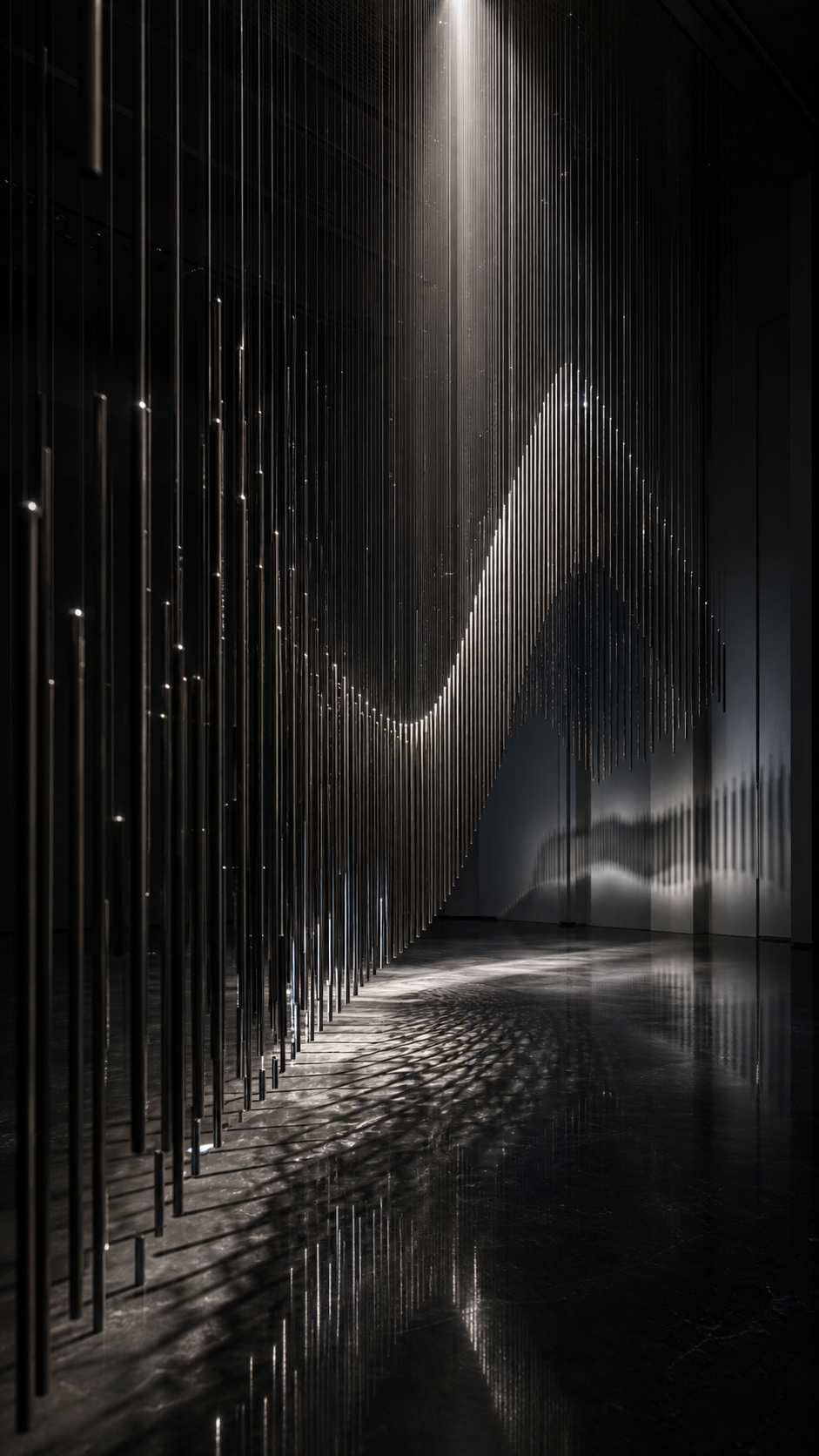 A curtain of black metal rods forming a wave under a vertical white spotlight.